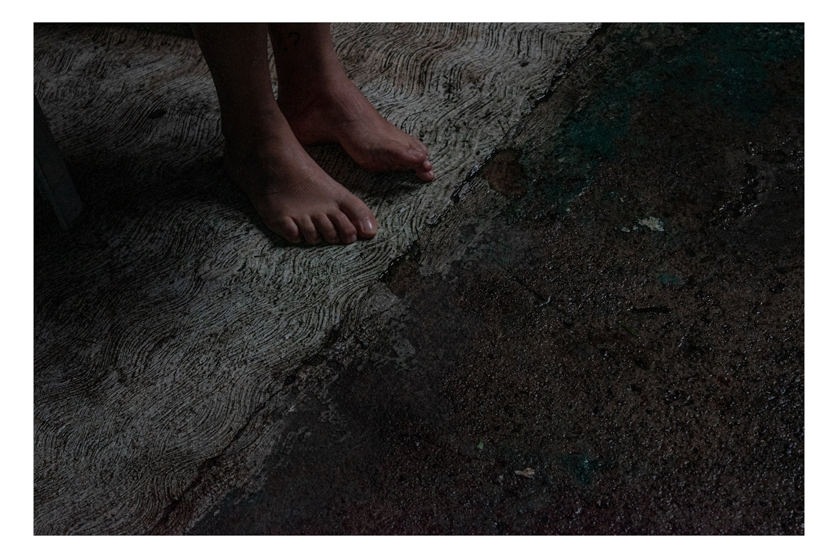 barefoot person standing on gray surface