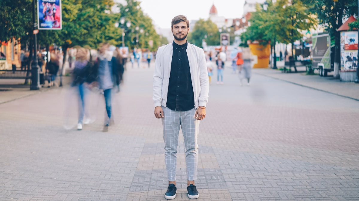 A man stands still in a busy street.