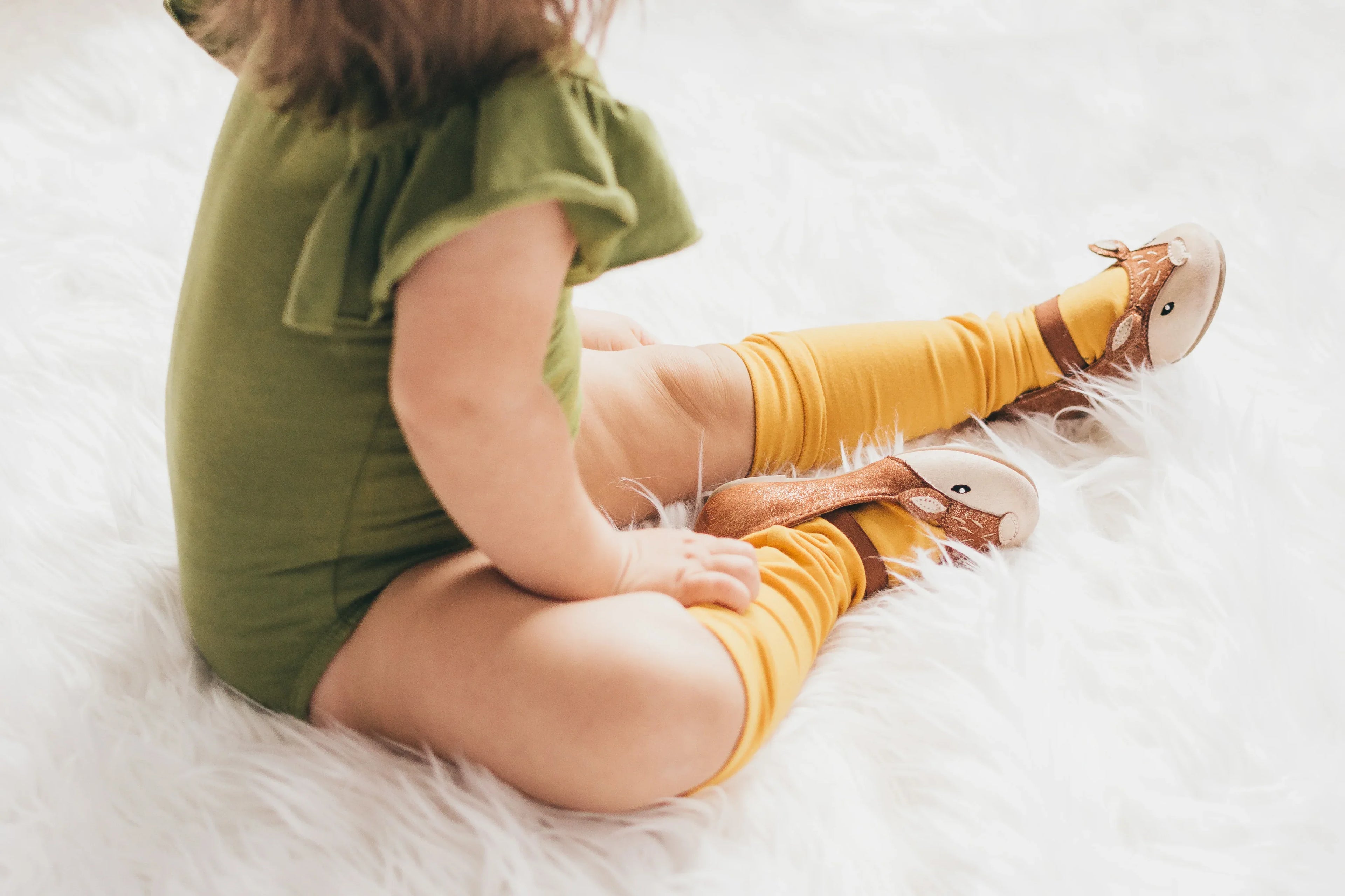 child-sits-on-fluffy-rug - Shoedeal