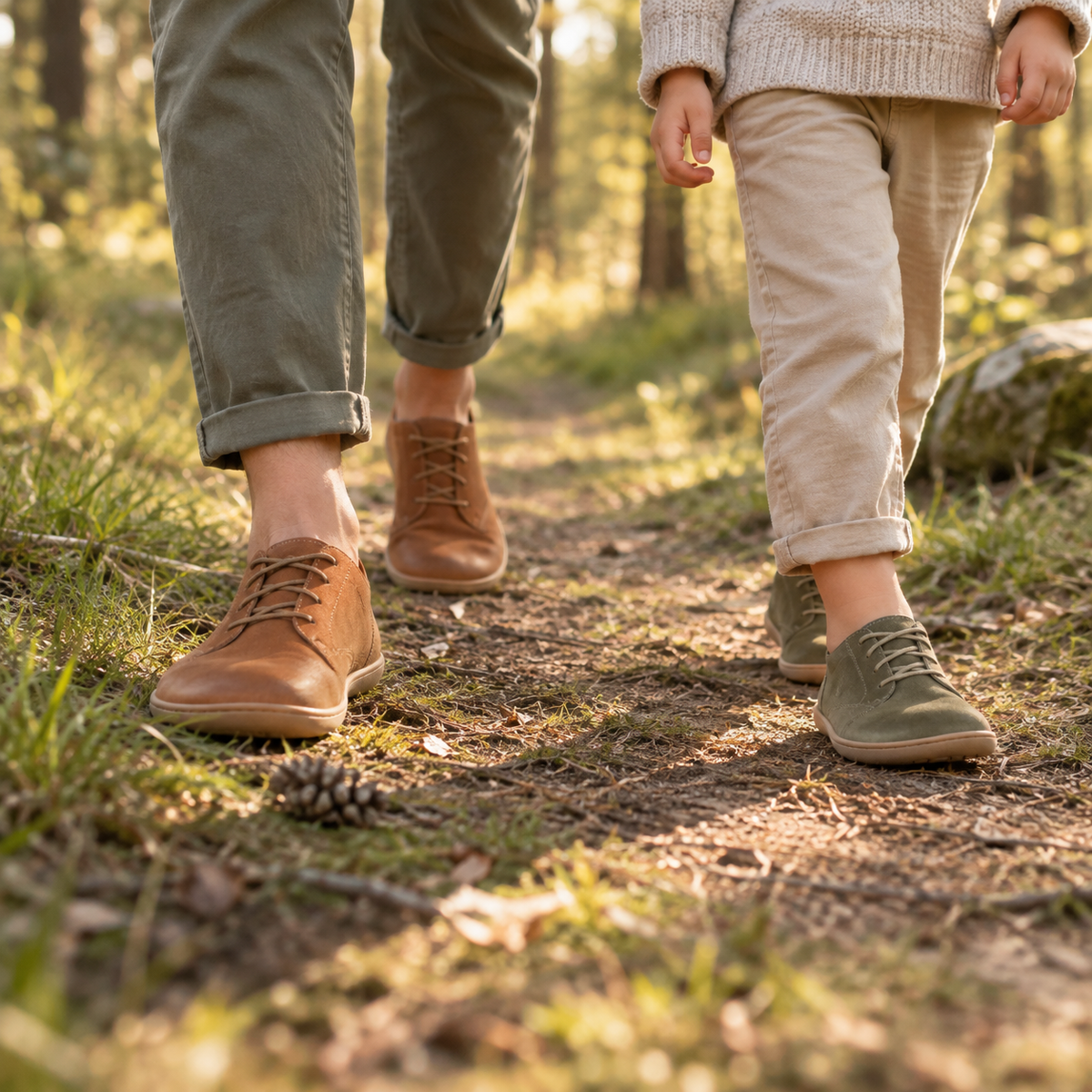 Erwachsener und Kind mit Barfussschuhen auf einem Waldweg